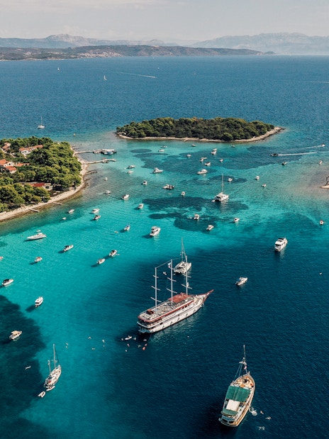Aerial view of boats in the Blue Lagoon, Croatia, surrounded by turquoise waters and lush islands.
