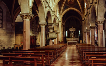 Interior of a historic church in Jakarta with ornate columns and altar.