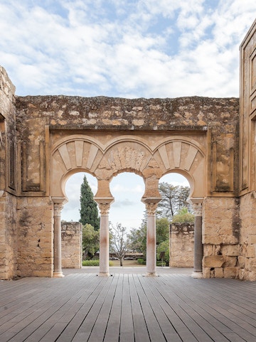 Medina Azahara arches in Cordoba, Spain, with stone walls and garden view.