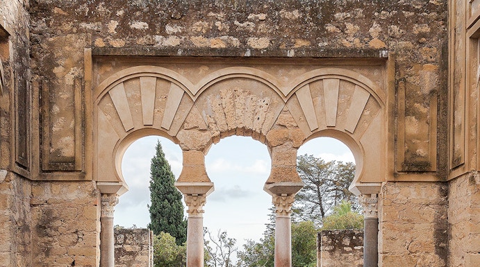 Medina Azahara arches in Cordoba, Spain, with stone walls and garden view.