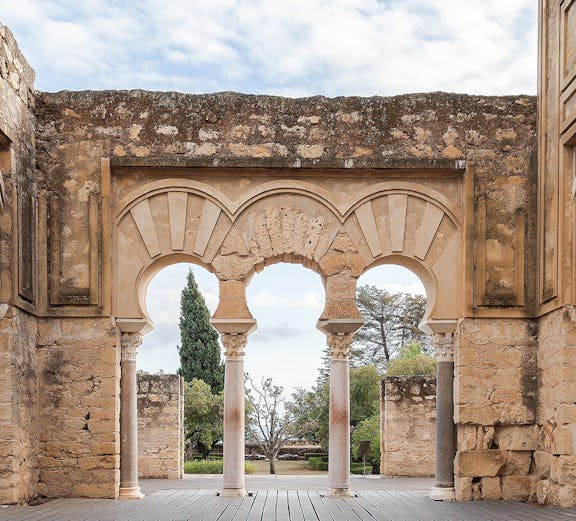 Medina Azahara arches in Cordoba, Spain, with stone walls and garden view.