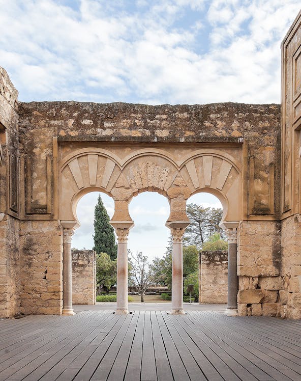 Medina Azahara arches in Cordoba, Spain, with stone walls and garden view.