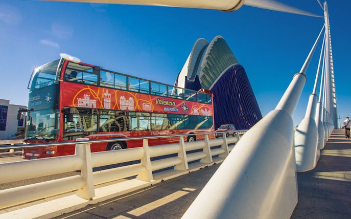 Valencia Hop On Hop Off bus crossing a modern bridge near the City of Arts and Sciences.