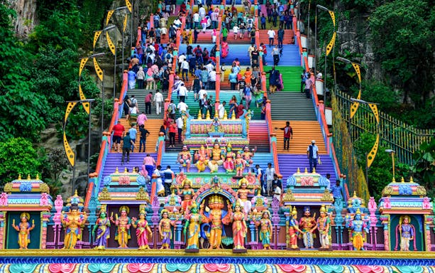Colorful steps leading to Batu Caves with visitors ascending, Malaysia.