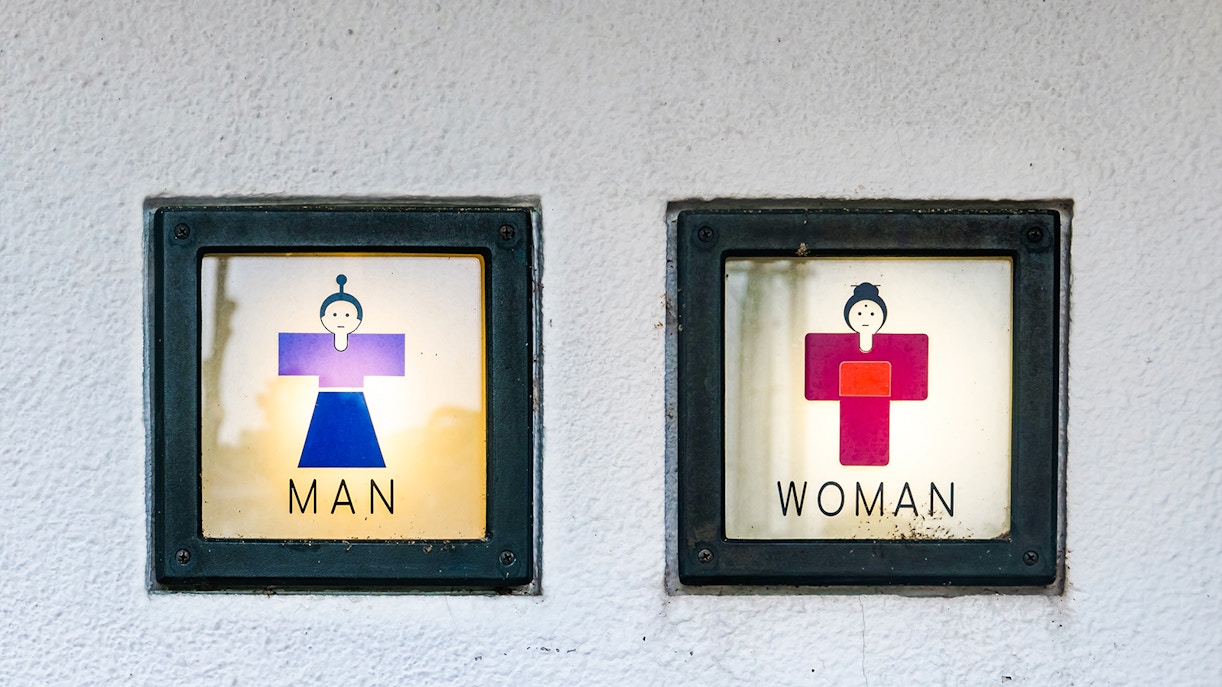 Public restroom signs in Japan with traditional clothing icons for men and women.
