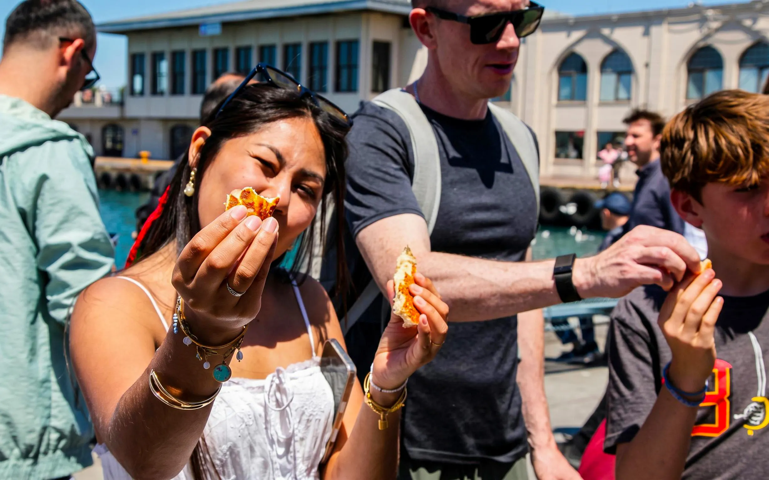 Tourists enjoying street food on an Istanbul food tour by the waterfront.
