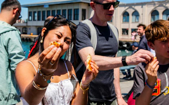 Tourists enjoying street food on an Istanbul food tour by the waterfront.