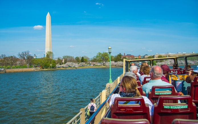 Tourists on open-top bus viewing Washington Monument, Washington DC.