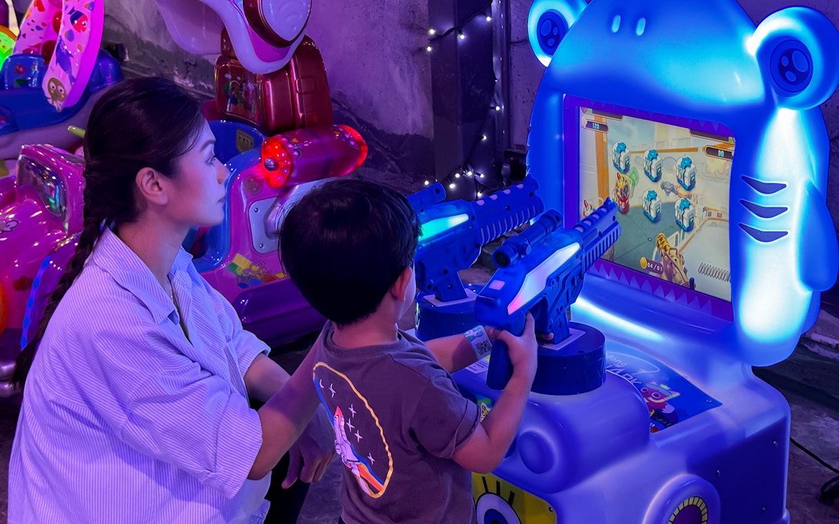 Child playing arcade shooting game at 99 Wonderland Park.