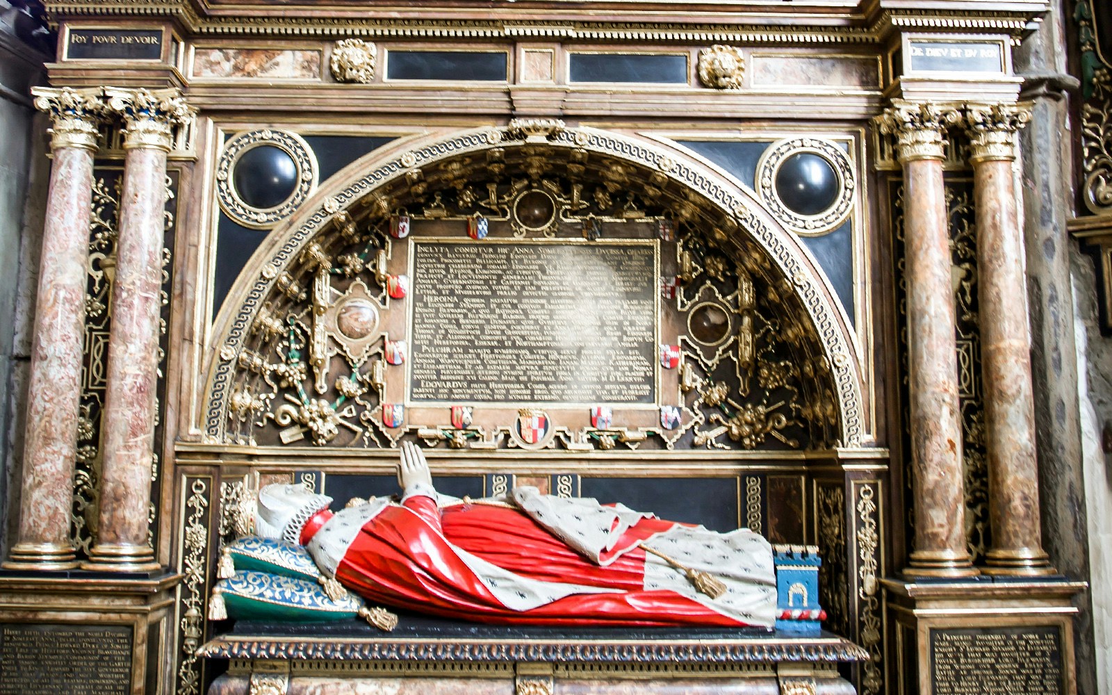 Tomb of a historical figure with ornate carvings and inscriptions at Westminster Abbey, London.