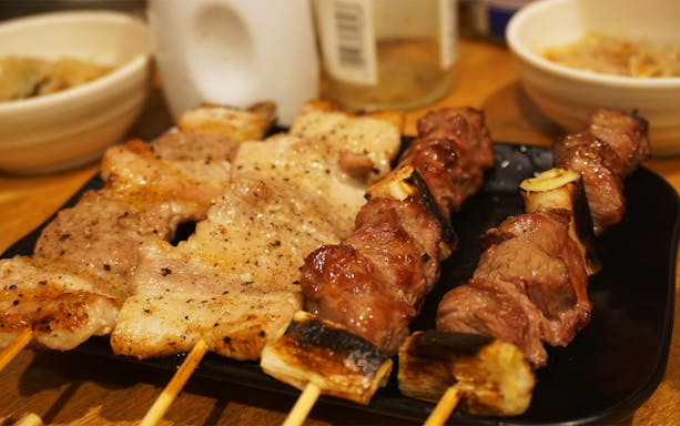 Grilled yakitori skewers on a plate during Shinjuku night out experience.