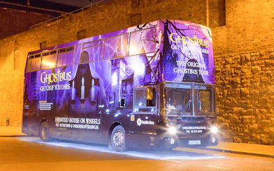 Dublin Ghostbus parked at night with eerie purple lighting and haunted imagery.