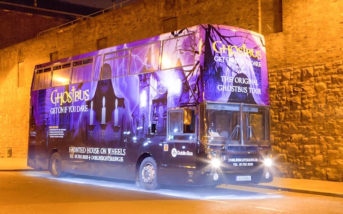 Dublin Ghostbus parked at night with eerie purple lighting and haunted imagery.