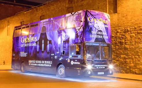 Dublin Ghostbus parked at night with eerie purple lighting and haunted imagery.