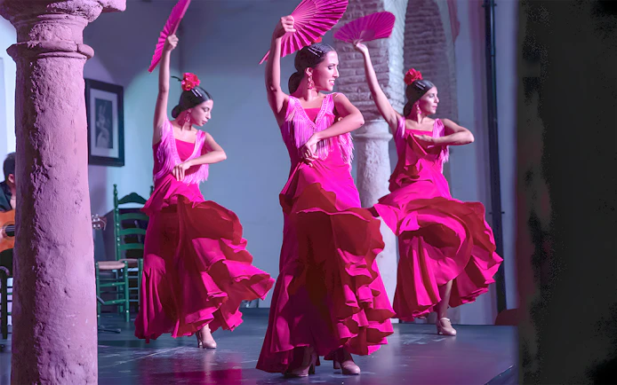 Flamenco dancers performing at Tablao Cardenal in vibrant pink dresses.