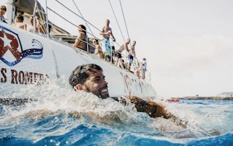 Man swimming near a boat during a mini cruise to Papagayo Beaches, Lanzarote.