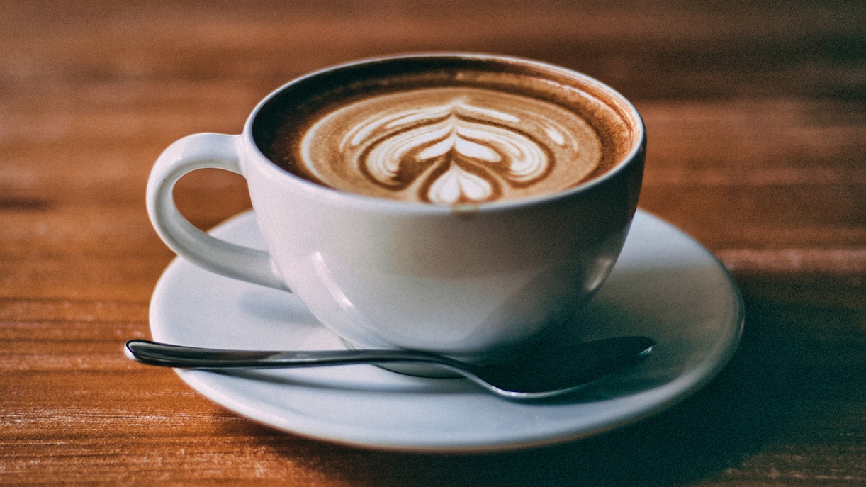 Cup of coffee with latte art served on a wooden table in Hamburg.
