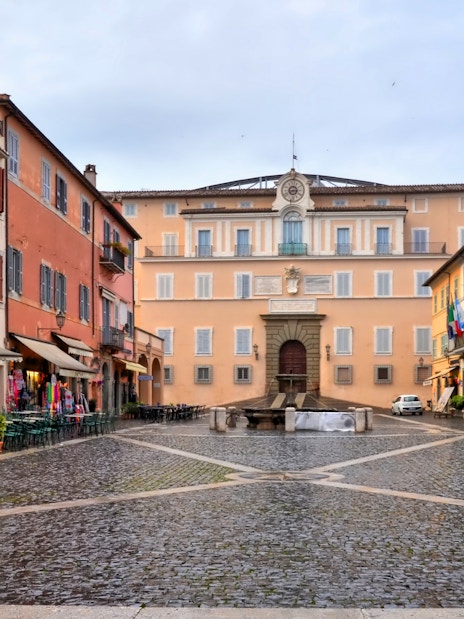 Piazza in front of Castel Gandolfo with cobblestone streets and surrounding buildings.