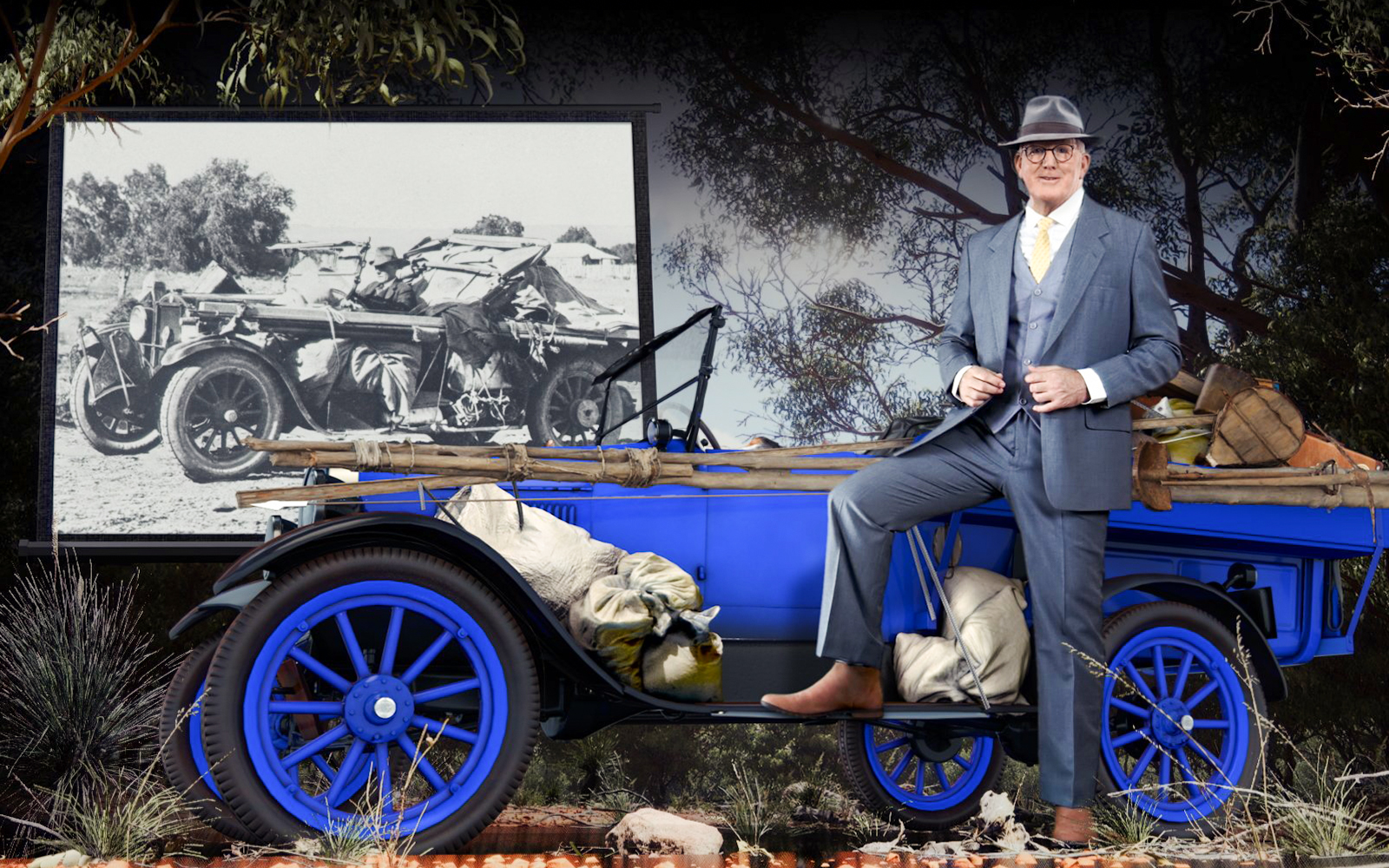 Man in suit with vintage car at Alice Springs Royal Flying Doctor Service exhibit.