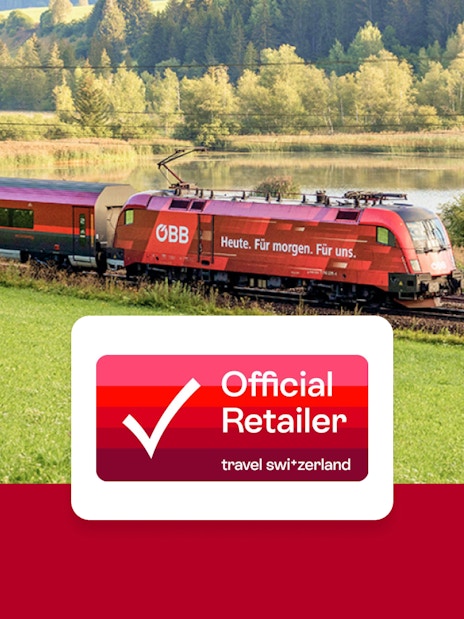 Eurail train traveling through scenic countryside with lake and forest views.