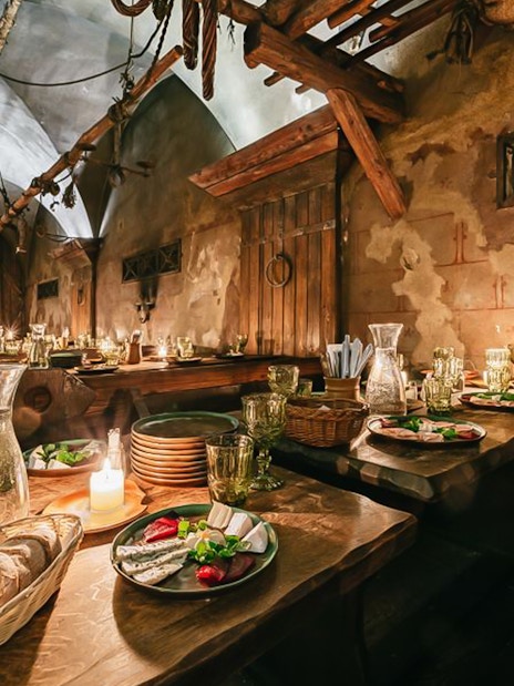 Medieval dining setup with three-course meal in Prague tavern.