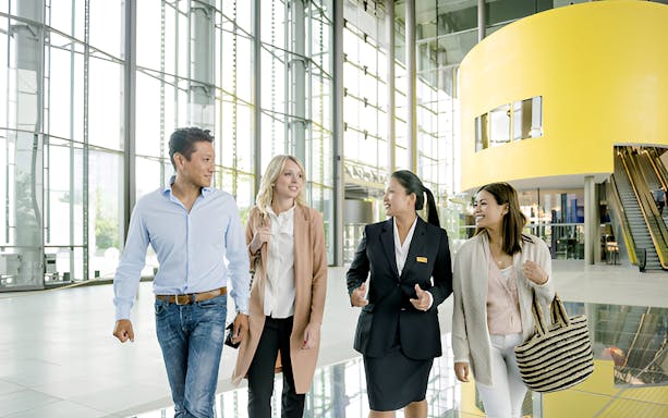 Visitors exploring Autostadt Theme Park in Wolfsburg with a guide.