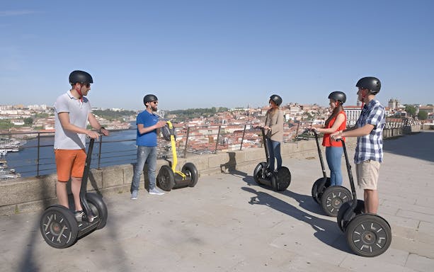 Riders on Segways exploring Porto's historic streets and landmarks during a guided city highlights tour.