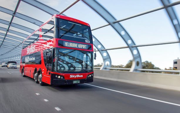 SkyBus traveling to Melbourne Airport on a highway bridge.