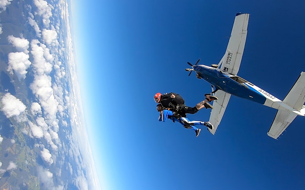 Tandem skydive over Sydney with view of plane and clouds.