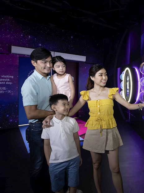 Family exploring interactive exhibit inside the Time Capsule, Singapore.