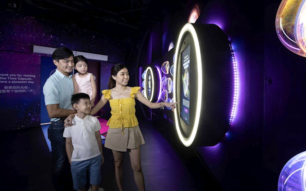 Family exploring interactive exhibit inside the Time Capsule, Singapore.
