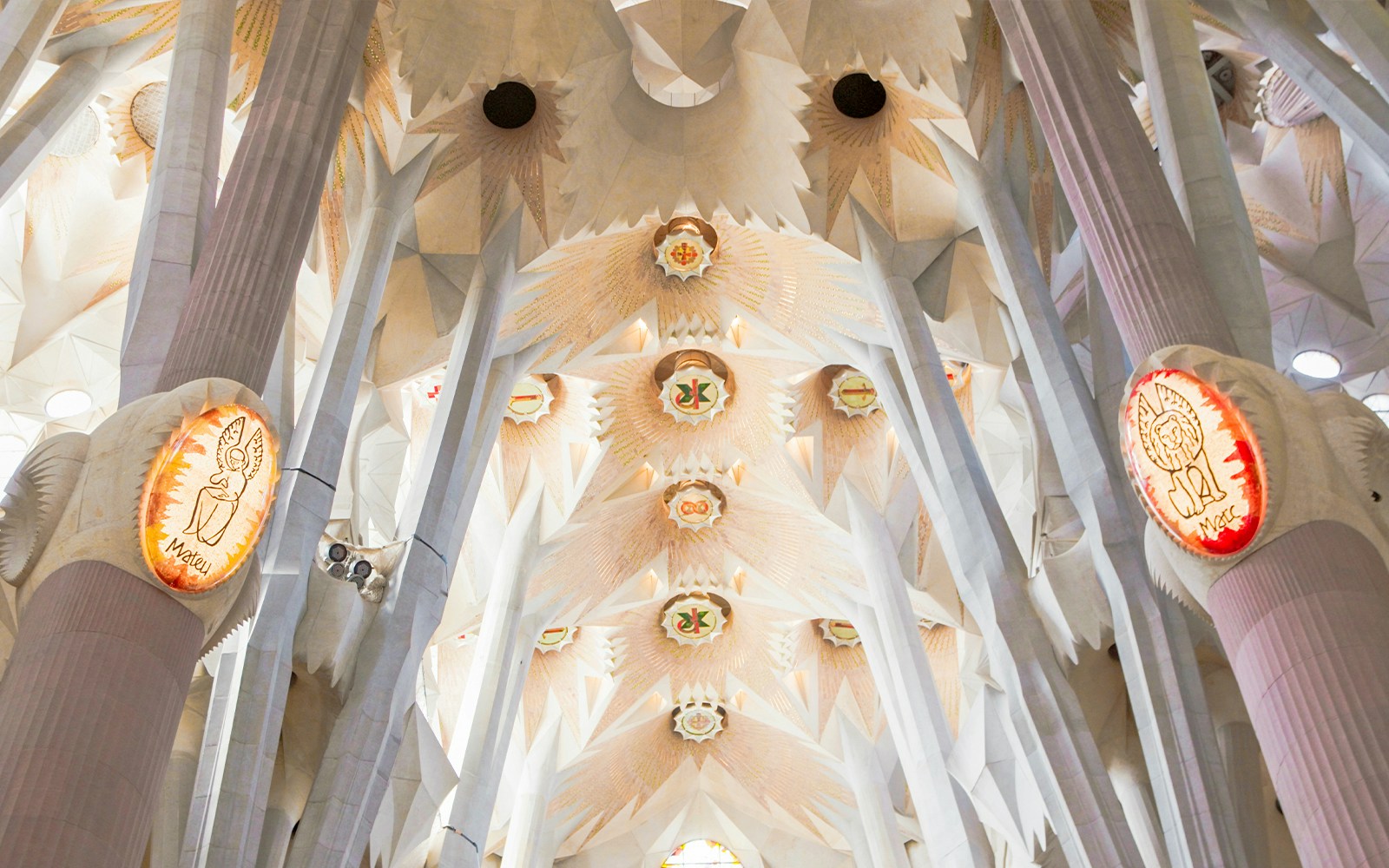 Sagrada Familia interior with towering columns and intricate vaulted ceiling in Barcelona.