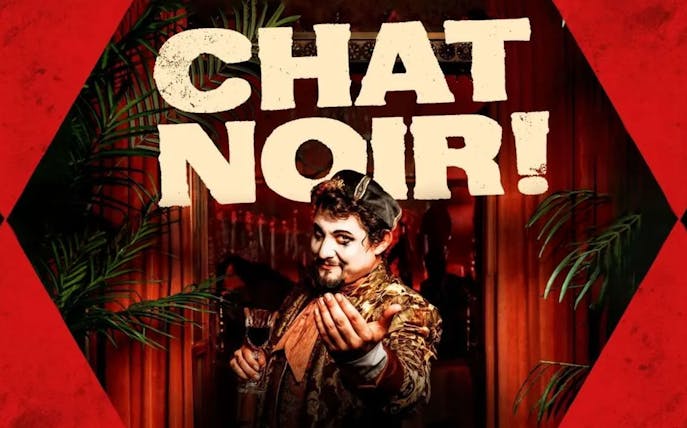 Performer in costume holding a glass at Chat Noir Westend show.