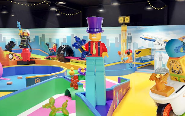Mini golf course with LEGO-themed obstacles at LEGOLAND® Adventure Golf in city.