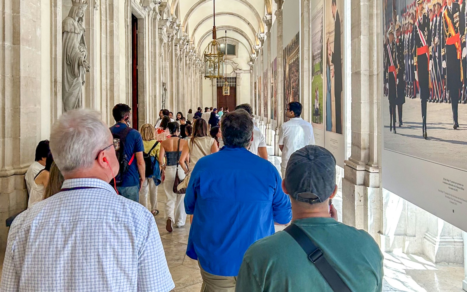 Royal Palace of Madrid exterior with tourists exploring the courtyard, Madrid, Spain.
