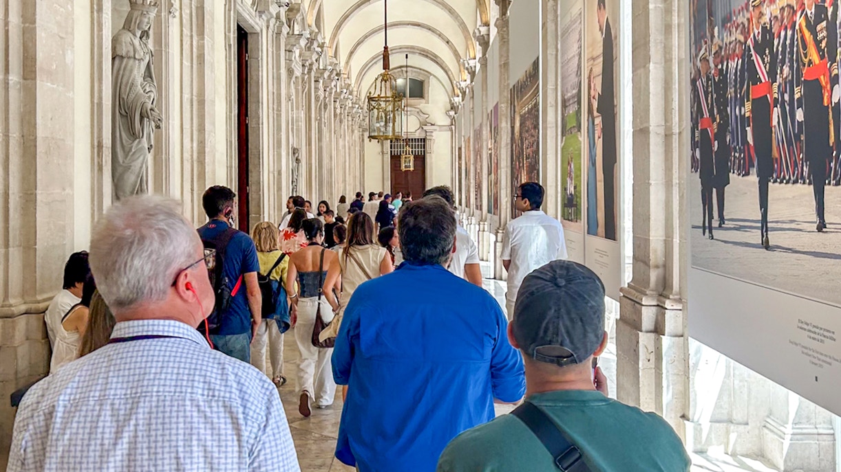 Tourists with a guide exploring the ornate interior of the Royal Palace of Madrid.