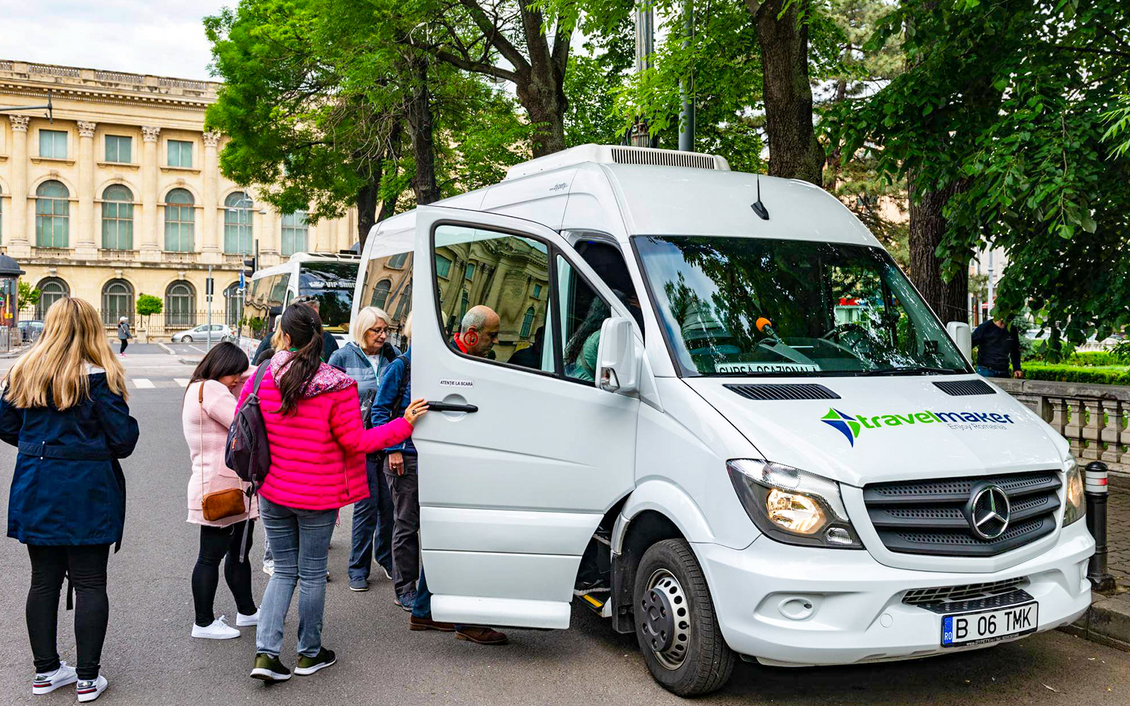 Visitors boarding AC transfer bus for full-day tour to Dracula’s Castle, Peles Castle, Brașov.
