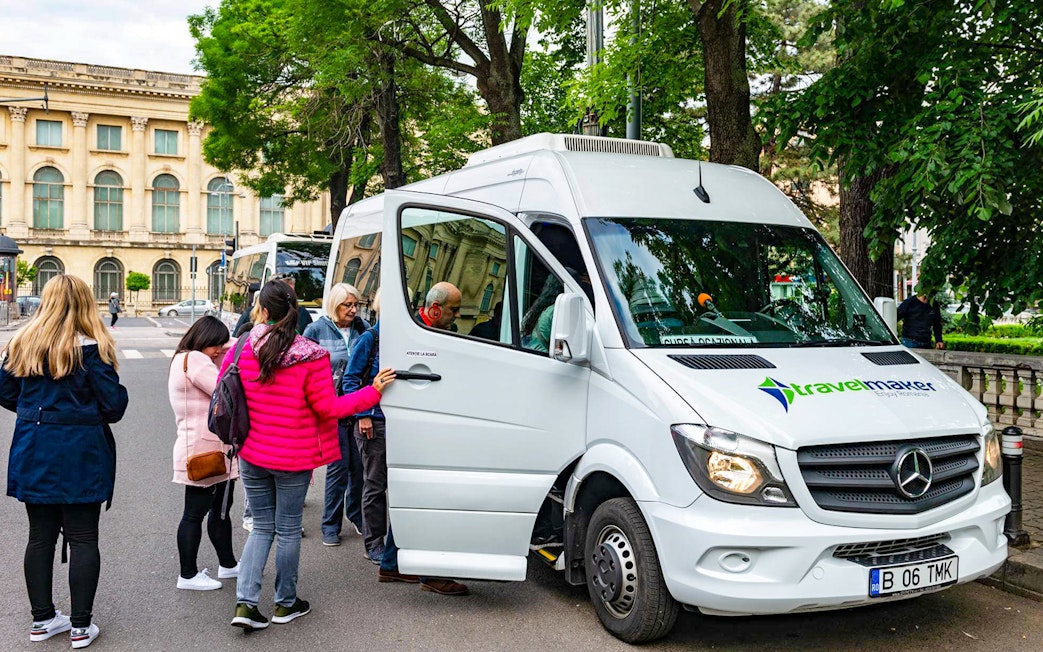 Visitors boarding AC transfer bus for full-day tour to Dracula’s Castle, Peles Castle, Brașov.