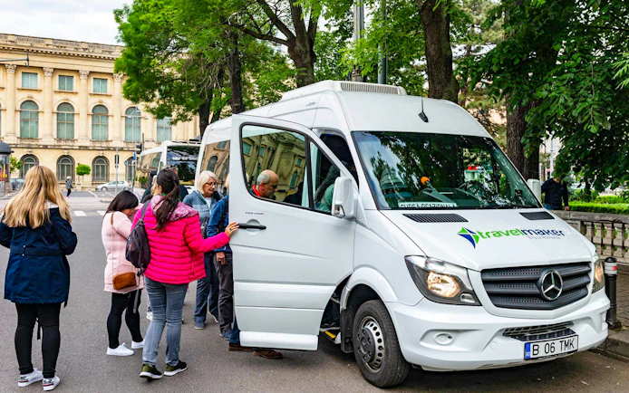 Visitors boarding AC transfer bus for full-day tour to Dracula’s Castle, Peles Castle, Brașov.