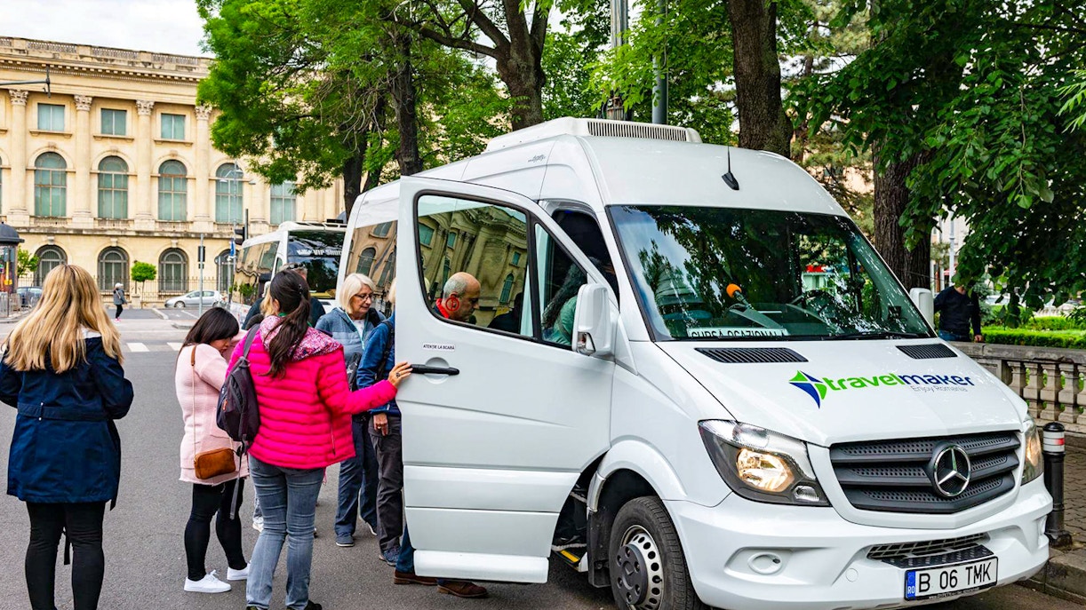 Visitors boarding AC transfer bus for full-day tour to Dracula’s Castle, Peles Castle, Brașov.