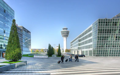 Munich airport control tower with travelers walking, part of Munich City Pass tour.