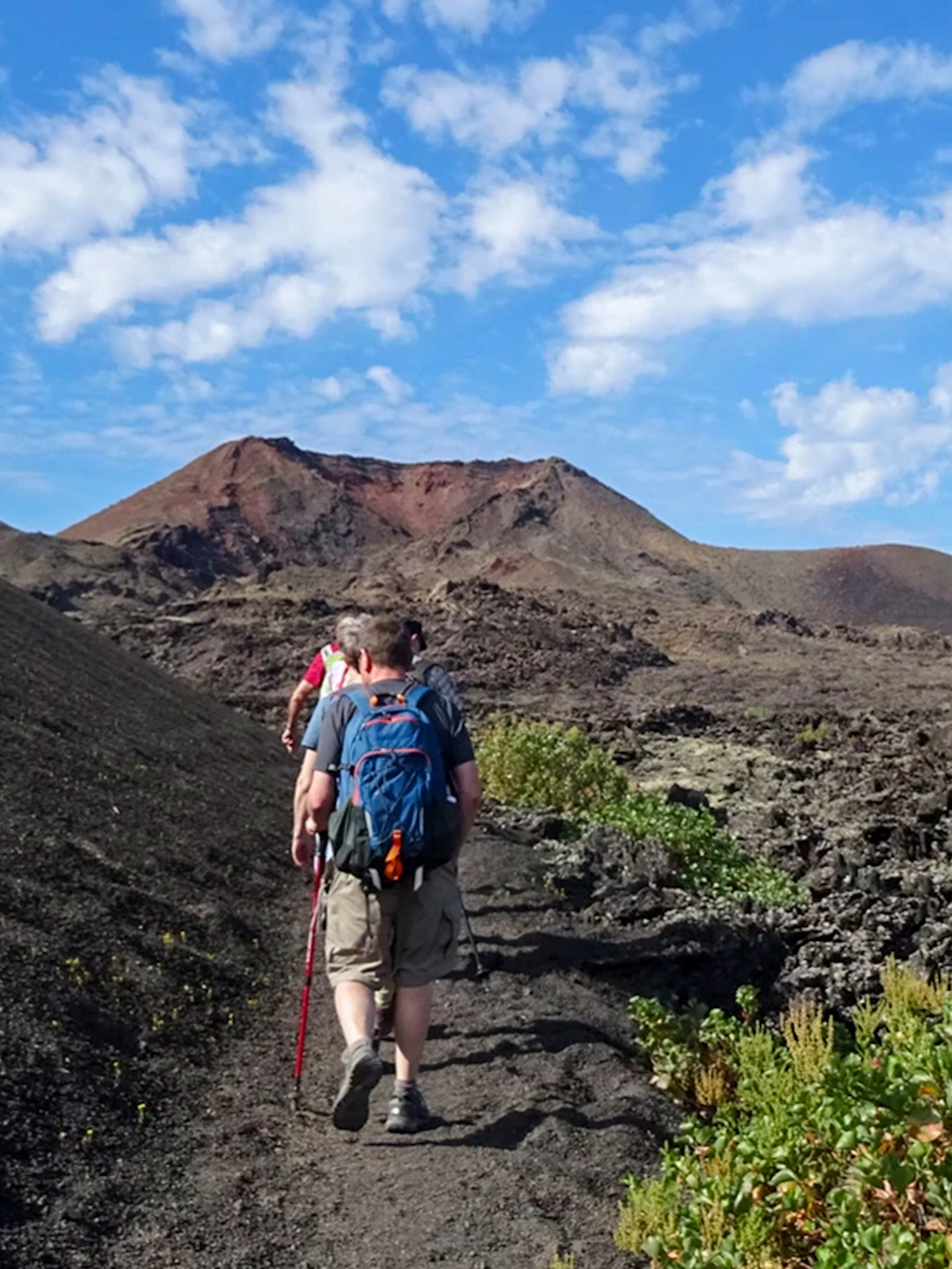 Hikers on a trail through volcanic terrain at Timanfaya National Park, Lanzarote.