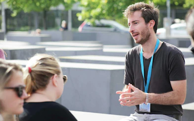 Male guide explaining history during Berlin World War II walking tour.