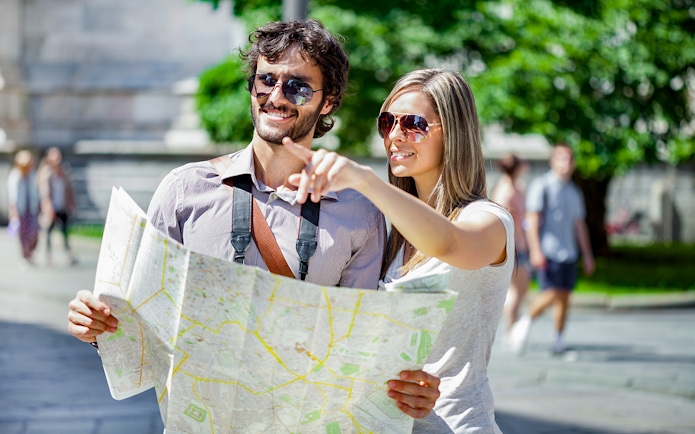 Tourists with a map exploring the Italian Riviera and Monaco.