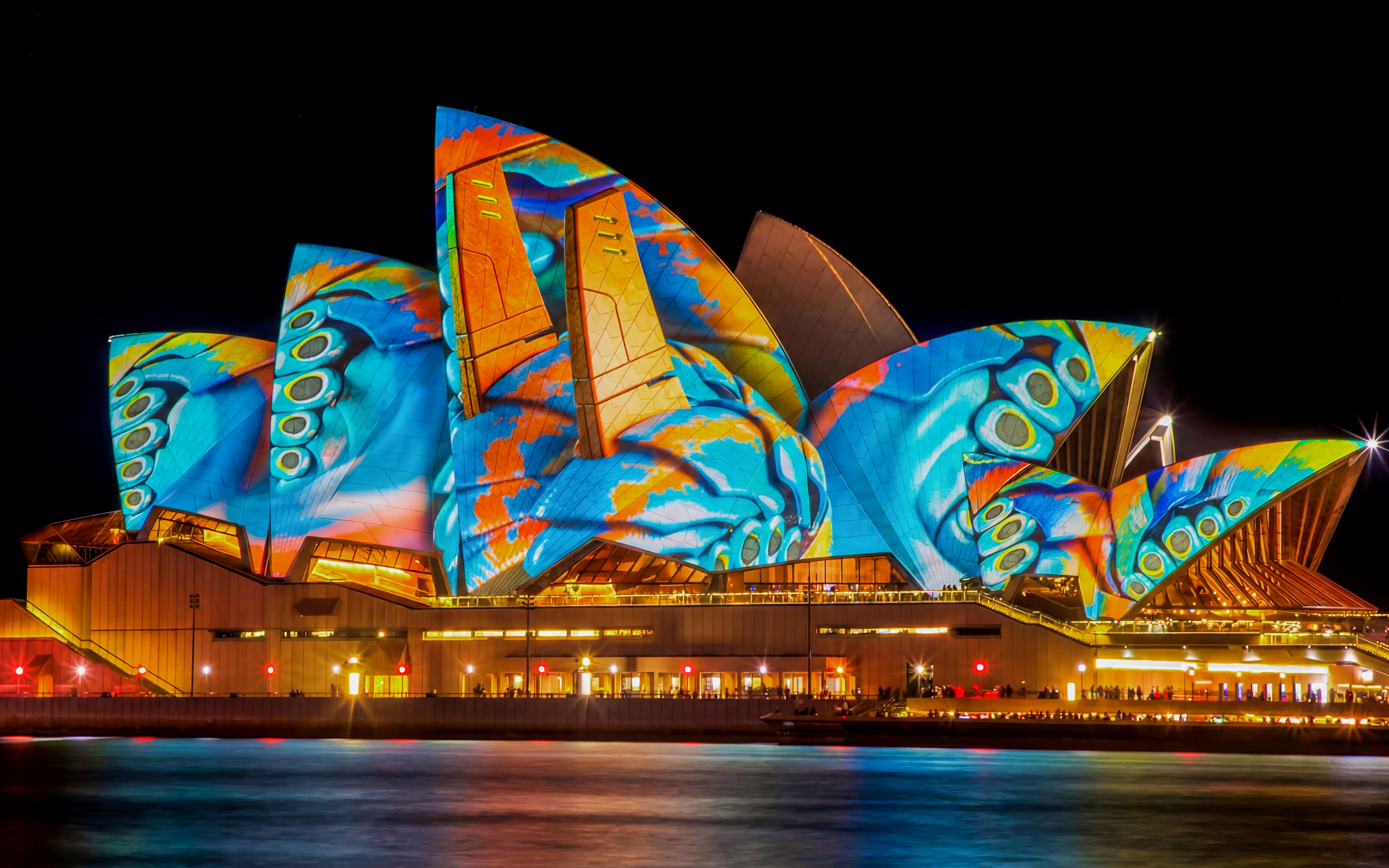 Sydney Opera House illuminated during Vivid Sydney festival, viewed from a dinner cruise.