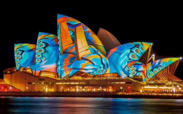Sydney Opera House illuminated during Vivid Sydney festival, viewed from a dinner cruise.