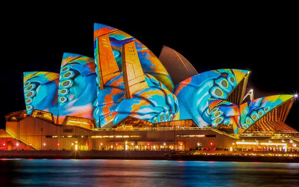 Sydney Opera House illuminated during Vivid Sydney festival, viewed from a dinner cruise.