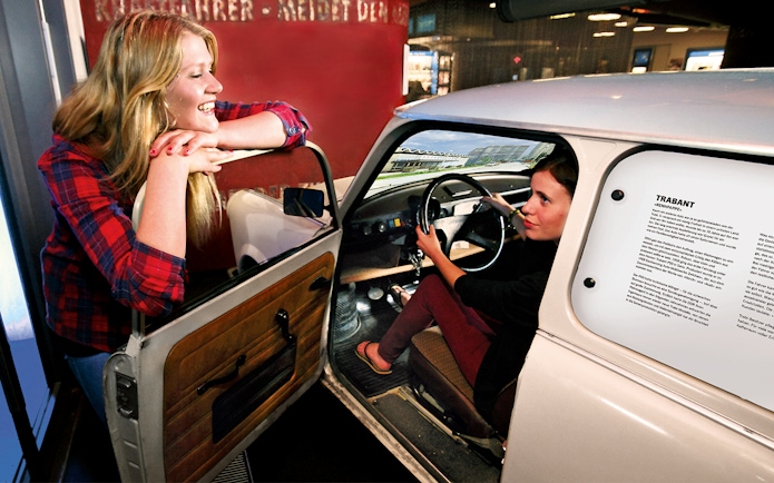 Person experiencing driving simulation in a Trabant at DDR Museum, Berlin.
