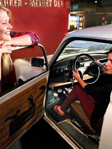 Person experiencing driving simulation in a Trabant at DDR Museum, Berlin.