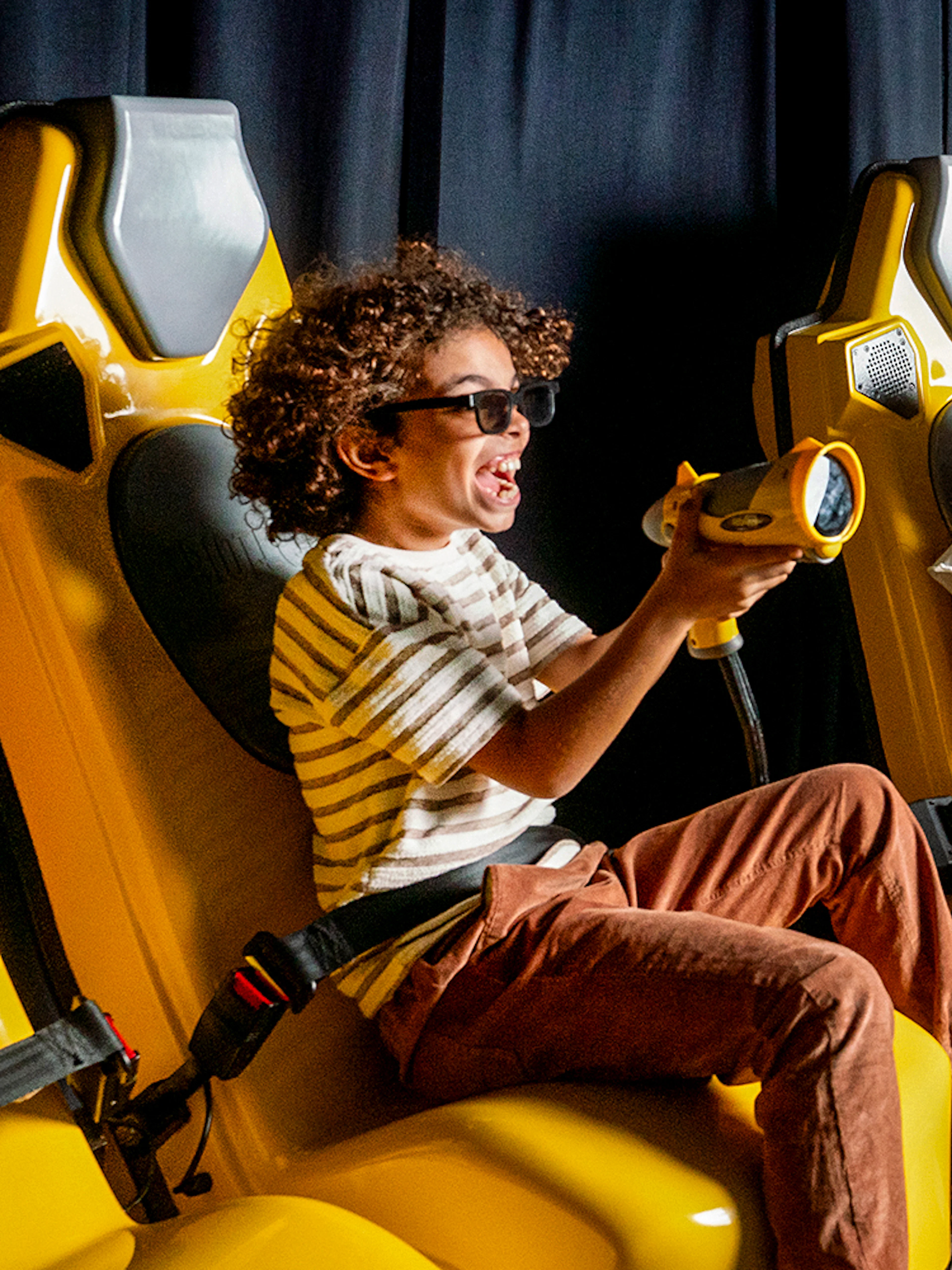 Children enjoying a virtual reality ride at Play DXB with interactive controls.